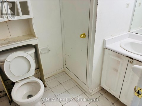 A bathroom with a toilet, sink, and medicine cabinet.