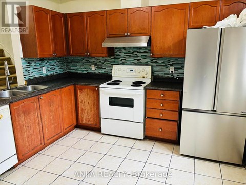 A kitchen with wooden cabinets and a stove top oven.