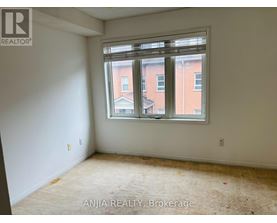 A room with a window showing a view of a building outside.