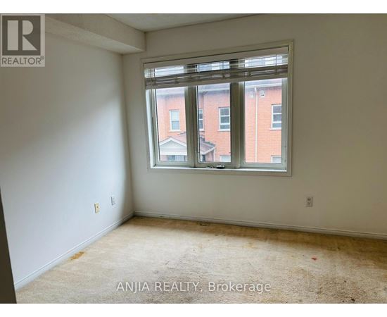 A room with a window showing a view of a building outside.