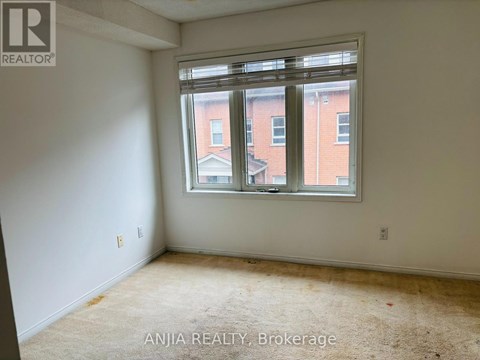 A room with a window showing a view of a building outside.