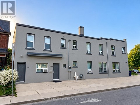 A grey building with the number 1128 on the front door.