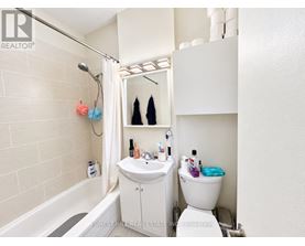 A white bathroom with a toilet, sink, and bathtub.
