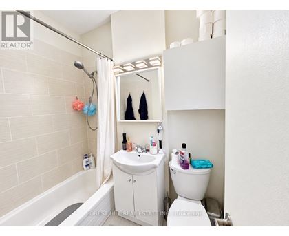 A white bathroom with a toilet, sink, and bathtub.