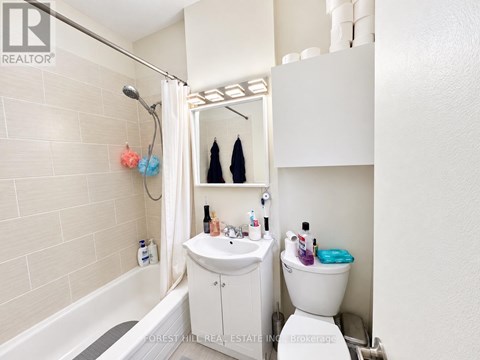 A white bathroom with a toilet, sink, and bathtub.