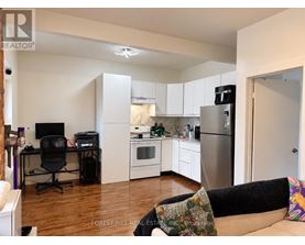 A kitchen with a refrigerator, oven, and microwave.