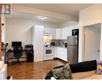 A kitchen with a refrigerator, oven, and microwave.