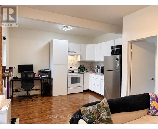 A kitchen with a refrigerator, oven, and microwave.
