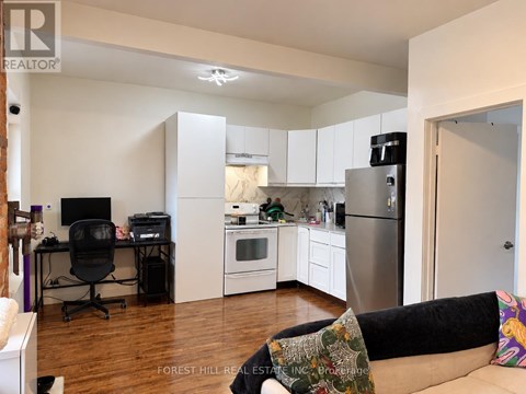 A kitchen with a refrigerator, oven, and microwave.