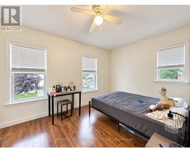 A bedroom with a bed, desk, and window.
