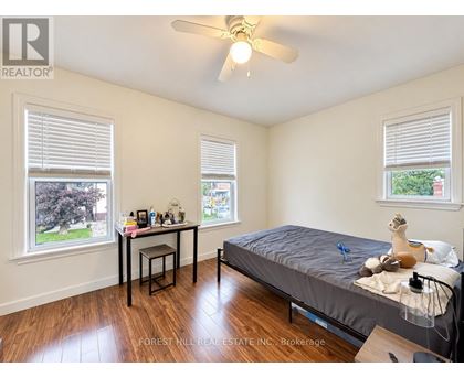 A bedroom with a bed, desk, and window.