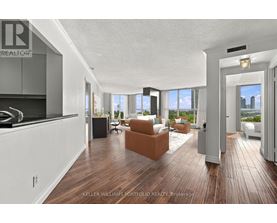 A modern living room with a kitchen area in the background.