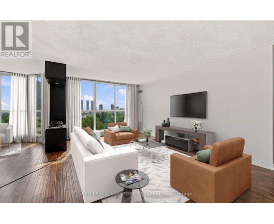 A living room with a white couch and a television on the wall.