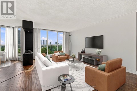 A living room with a white couch and a television on the wall.