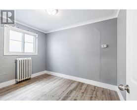 A room with a white radiator and wooden flooring.