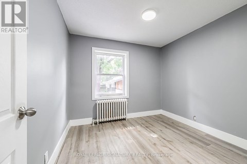 A room with a door, window, and radiator.