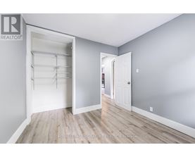 A white door is open to reveal a walk-in closet with shelves.