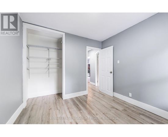 A white door is open to reveal a walk-in closet with shelves.