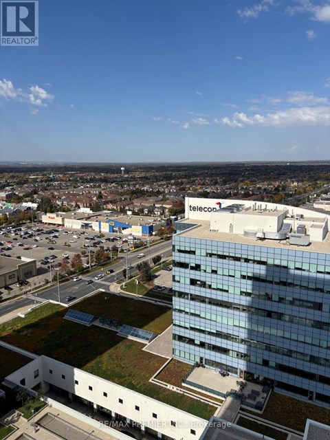 A large building with the word "telecom" on it is in the center of a parking lot.