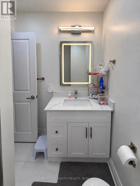 A bathroom with a sink, mirror, and medicine cabinet.