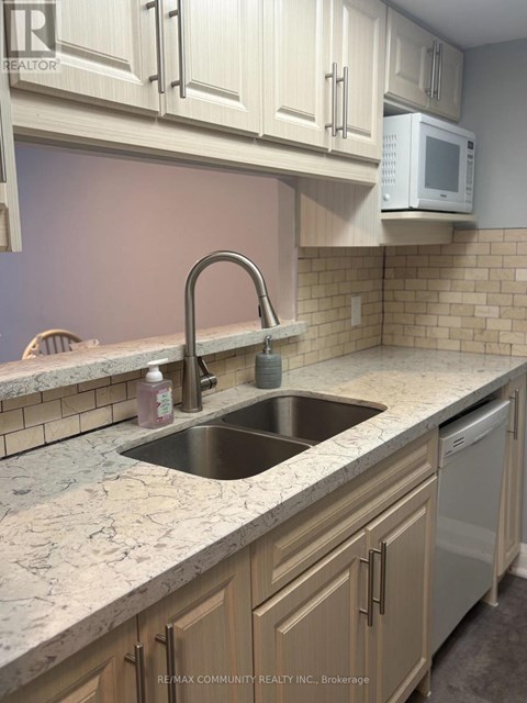 A kitchen with a sink and a microwave.