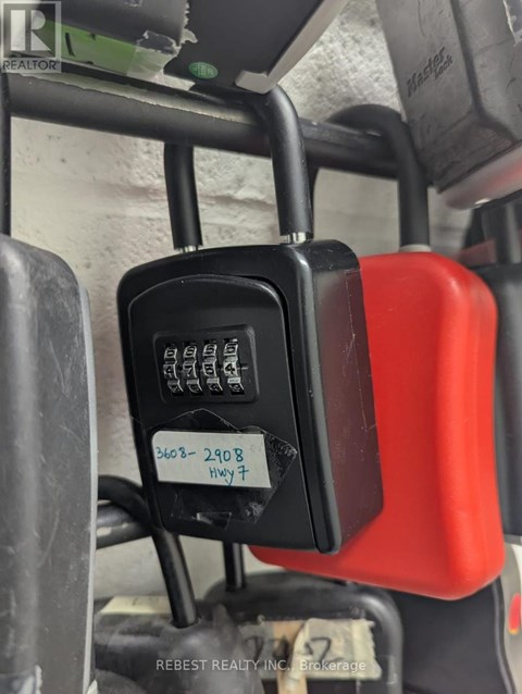 A bus seat with a red cover and a black device attached to it.