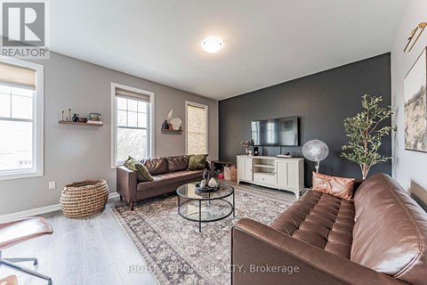 A living room with a brown leather couch and a glass coffee table.
