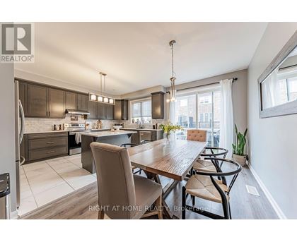 A modern kitchen and dining area with a wooden table and chairs.