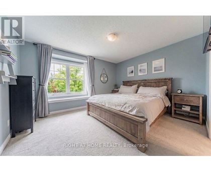 A bedroom with a large bed and a window with curtains.