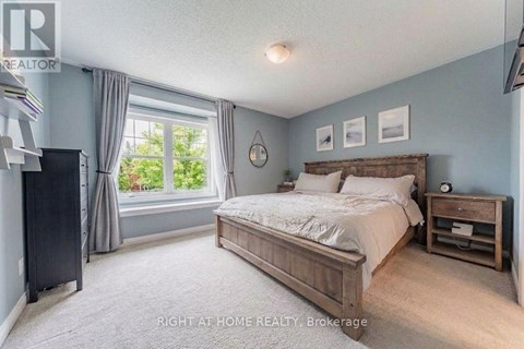 A bedroom with a large bed and a window with curtains.