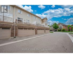 A sunny day at a residential street with apartment buildings and garages.
