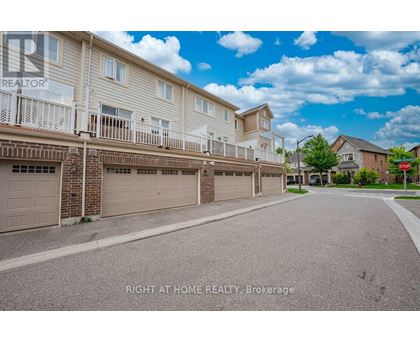 A sunny day at a residential street with apartment buildings and garages.