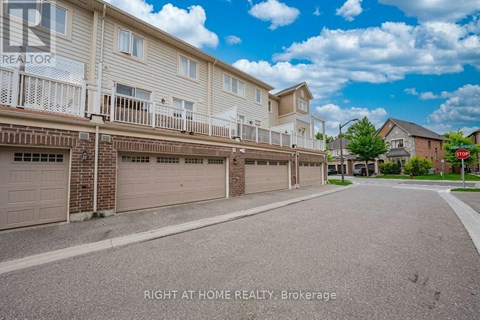 A sunny day at a residential street with apartment buildings and garages.