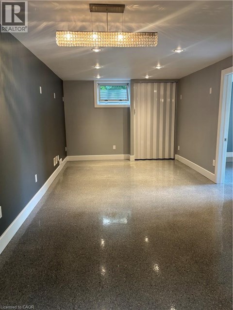 A spacious room with a window and a chandelier.