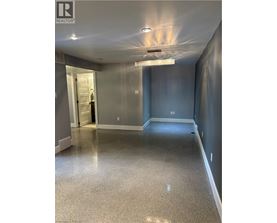 A spacious hallway with a light on the ceiling and a door on the left.
