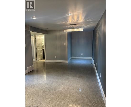 A spacious hallway with a light on the ceiling and a door on the left.