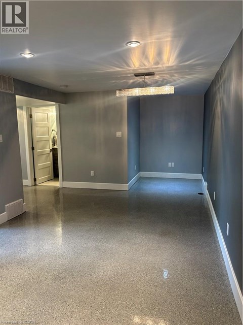 A spacious hallway with a light on the ceiling and a door on the left.