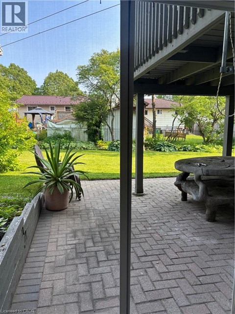 A patio with a brick walkway and a potted plant.