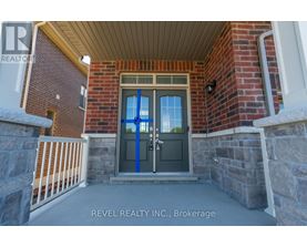 A house entrance with a blue door and a sign that says REVEL REALTY N.C. Brokerage.