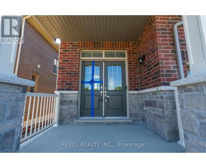 A house entrance with a blue door and a sign that says REVEL REALTY N.C. Brokerage.