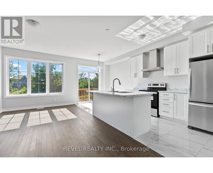 A modern kitchen with white cabinets and stainless steel appliances.