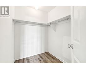 A white bedroom with a door and a window with blinds.