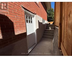 A narrow alley with a white door and steps leading up to it.