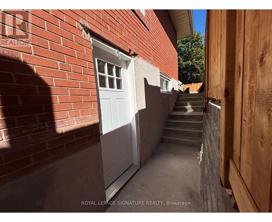 A narrow alley with a white door and steps leading up to it.