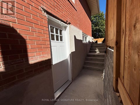 A narrow alley with a white door and steps leading up to it.