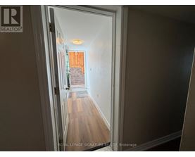 A hallway with a doorway leading to a balcony.