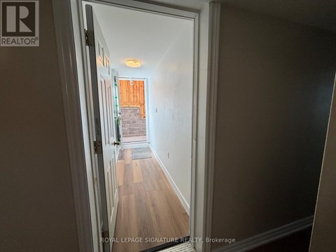 A hallway with a doorway leading to a balcony.