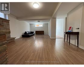 A living room with wooden floors and a stone fireplace.