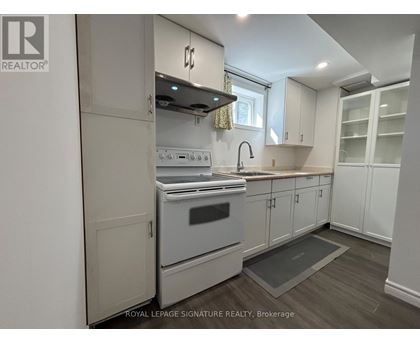 A kitchen with a stove top oven and a sink.