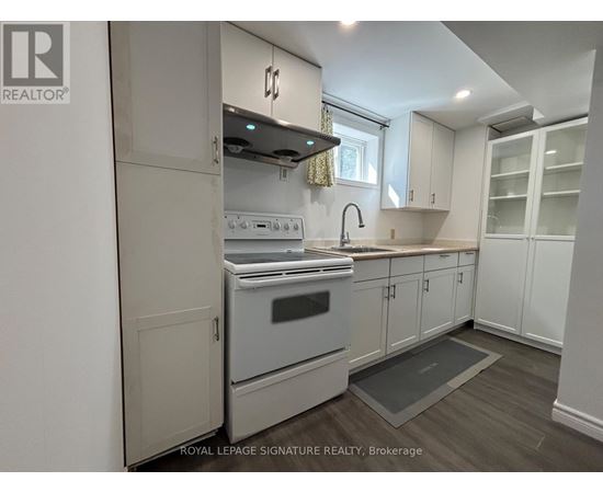 A kitchen with a stove top oven and a sink.
